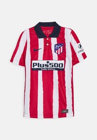 Polo de rayas rojas y blancas con cuello azul marino. Presenta el logo de Nike, el escudo del equipo y el texto del patrocinador "Plus500" en el frente.