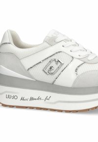 Baskets blanches en mesh et daim, avec des accents argentés et une semelle épaisse. Elles présentent un logo et le texte "Maxi Wonder...ful" sur le côté.