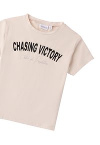Camiseta de color beige claro con mangas cortas, que presenta texto bordado en negro "CHASING VICTORY" y un script más pequeño debajo. Tejido de algodón suave.