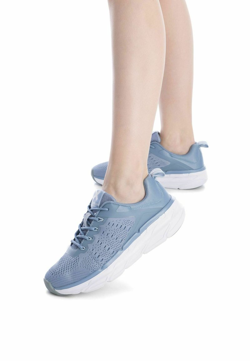 Zapatillas deportivas de color azul claro con una parte superior de malla transpirable, cierre de cordones y una suela blanca gruesa; presenta agujeros de ventilación y una lengüeta en la parte trasera.