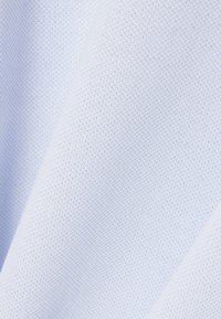 Hellblauer Stoff mit einem strukturierten, gewebten Muster. Das Material wirkt weich und leicht dehnbar, ideal für Bekleidungsanwendungen.