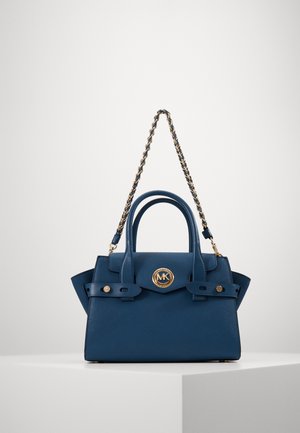 Granatowa skórzana torebka z złotym paskiem łańcuszkowym, podwójnymi zwiniętymi uchwytami i okrągłym złotym logo Michael Kors z przodu.