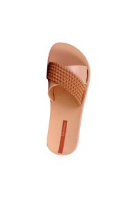 Enkelt beige slide sandal med tekstureret vævet rem og blomsterprydet sål, mærket "Ipanema" på indersålen.
