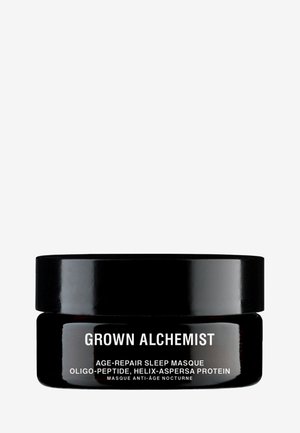 Schwarzes rundes Glas mit glänzender Oberfläche, beschriftet mit "Grown Alchemist Age-Repair Sleep Masque." Fette weiße Schrift beschreibt die Inhaltsstoffe auf der Vorderseite.
