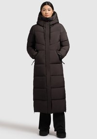 Pikk must puffer-jakk kõrge kraega, vertikaalse riide tehnika, lukuga taskud ja reguleeritava tõmbluku kapuutsiga, esitatud neutraalsel taustal.