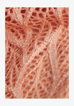Gaisma korallkrāsas adīta auduma ar atvērtu mežģīņu rakstu. Strukturēts, gaisīgs dizains ar izsmalcinātiem ģeometriskiem motīviem un mīkstām šķiedrām.