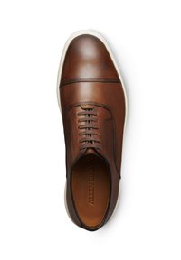 Bruine leren schoen met een gladde afwerking, voorzien van gestikte details, ronde vetersluiting en een contrasterende witte rubberen zool.