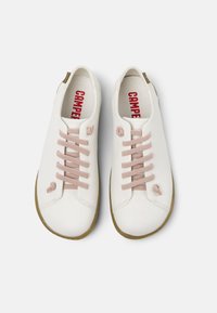 Scarpe in pelle bianca con lacci rosa, punta rotonda e suola in gomma beige. Presentano un marchio rosso sulla soletta e cuciture testurizzate.