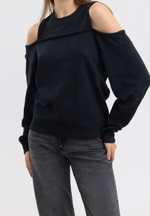 Felpa nera con spalle scoperte, scollo rotondo e maniche lunghe. Realizzata in materiale morbido, presenta polsini e orlo inferiore a coste.