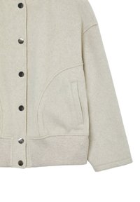 Veste en laine beige avec des boutons-pression, un ourlet côtelé, une poche latérale et des manches longues, présentée de la taille au milieu du bras sur fond blanc.