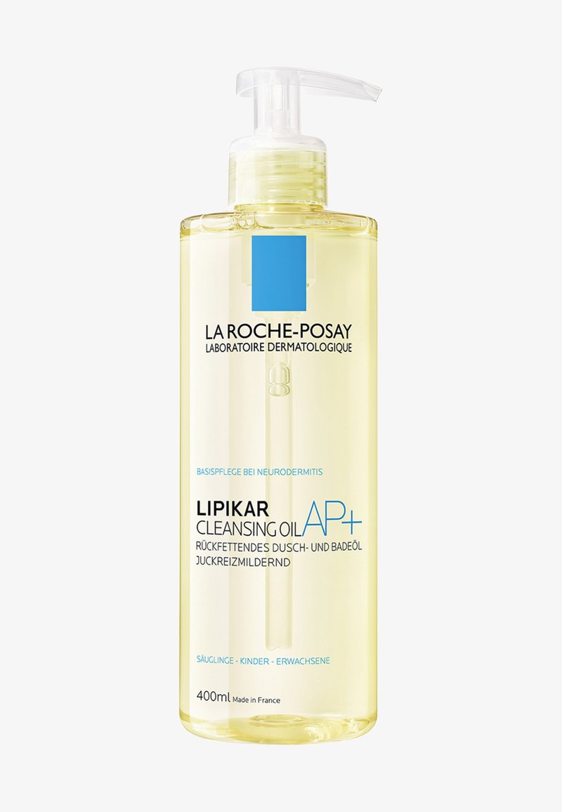 Clear plastic pump bottle with 400ml of light yellow cleansing oil. Features a blue square logo and labels in German and English.
