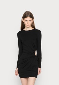 Vestido preto de mangas longas com um design ajustado. Apresenta um detalhe de textura torcida na cintura e um recorte lateral aberto. Tecido suave.