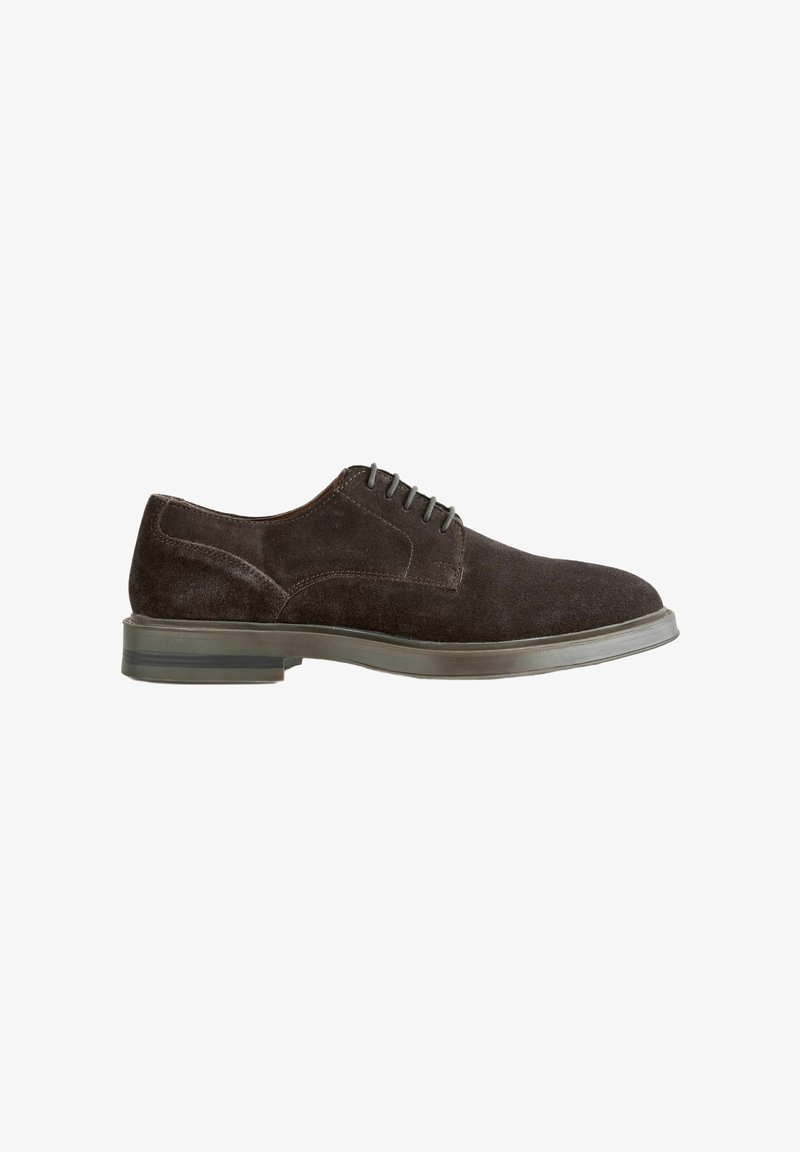 Chaussure habillée pour homme en daim marron foncé, à fermeture à lacets et petit talon, présentée en profil latéral sur un fond blanc.