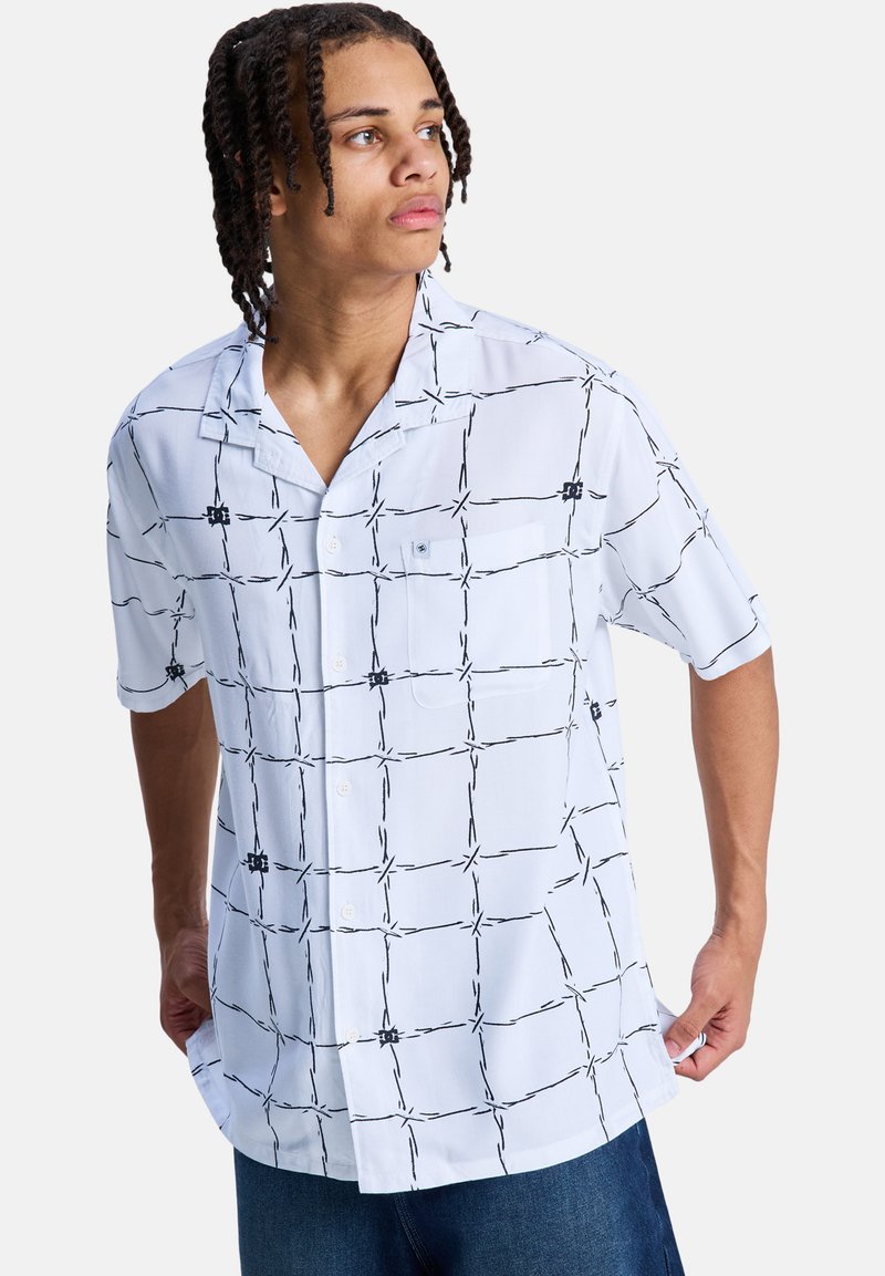 Koszula na guziki z krótkim rękawem w jasnoniebieskim kolorze z czarnym wzorem w kratę. Posiada kieszeń na lewej piersi i luźny krój. Materiał z mieszanki bawełny.