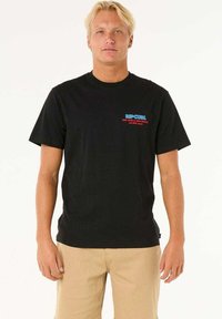 Sort bomulds t-shirt med korte ærmer, med et blåt og rødt "Rip Curl"-logo på venstre bryst. Klassisk pasform og blød tekstur.