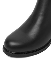 Botină din piele neagră, până la glezne, cu vârf rotund, textură netedă, detalii minime de cusături și un talpă din cauciuc rezistentă.