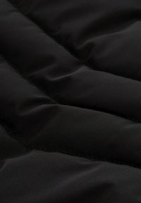 Zwarte gewatteerde stof met een gladde textuur, met duidelijke horizontale naden die een quiltpatroon creëren. Lichtgewicht en zacht om aan te raken.