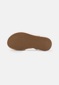 Brown rubber outsole with textured pattern, featuring a rounded shape and slight curvature, designed for traction and durability.