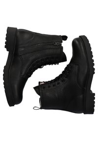 Paire de bottes noires en cuir à lacets avec fermetures éclair latérales et semelles épaisses et robustes, positionnées talon contre talon sur un fond blanc.