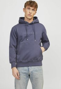 Námornícky mikina s kapucňou, šnúrkami a predným vreckom. Obsahuje embosovaný text "ORIGINALS". Mäkký materiál, voľný strih a rebrované manžety.