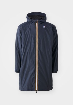 Giacca impermeabile blu navy con zip frontale, dotata di un accento giallo brillante, maniche lunghe e cappuccio con coulisse. Tessuto leggero.