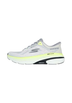 Zapatilla deportiva de color gris claro con parte superior de malla, suela negra, acentos amarillos y tecnología de amortiguación. Cuenta con cordones y un diseño de punta redondeada.