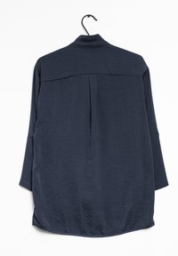 Mörkblå långärmad skjorta, lättviktsmaterial, avslappnad passform, detalj med plissér bak, rundad nederkant, knäppta ärmslut och krage.