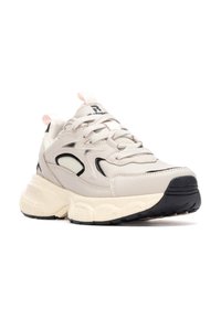 Zapatilla deportiva beige con acentos negros, parte superior sintética texturizada, suela gruesa y tirador en rosa pastel. Diseño con cordones y cuello acolchado.