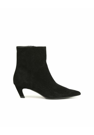 Zwarte suède enkellaars met spitse neus en lage kittenhak, zijritssluiting, gladde textuur, op witte achtergrond.