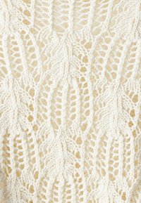 Pletený svetr s komplikovaným vzorem listů, vyrobený z tlusté příze v krémové barvě s texturovaným, vzdušným vzhledem.