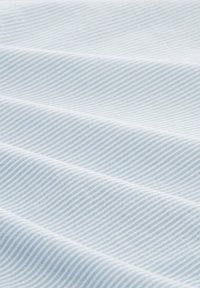 Tela azul clara con finas rayas blancas, mostrando una textura suave y un patrón consistente, doblada para revelar profundidad y dimensión.
