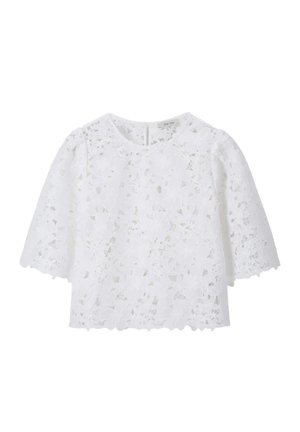 Blouse en dentelle blanche avec motif floral découpé, manches courtes et encolure ronde.