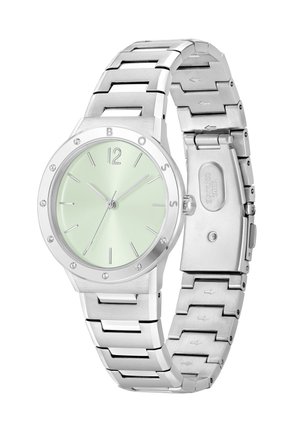 Montre en acier inoxydable avec un cadran vert menthe, marqueurs d'heure en argent et accents en cristal. Elle dispose d'un bracelet à maillons et d'un fermoir sécurisé.