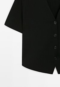 Cardigan nero a maniche corte con scollatura a V, tessuto testurizzato e sei bottoni neri sul davanti; design con orlo curvo.