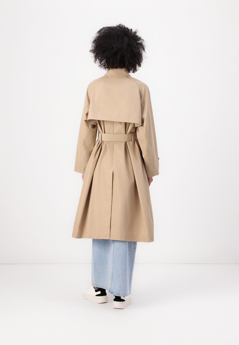 Khakifarbener Trenchcoat mit doppelter Knopfleiste, tailliertem Design und gefälteltem Rücken. Verfügt über lange Ärmel und ein geschichtetes Rückenteil.