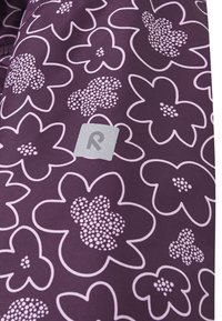 Lilla stof med et blomstermønster i lyserød med prikkede detaljer. En lille grå label med bogstavet "R" er synlig.