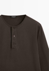 Dunkelbraunes Langarm-Henley-Shirt mit rundem Ausschnitt und drei Knöpfen an der Knopfleiste, Etikett lautet Massimo Dutti.