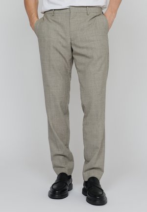 Pantaloni gri deschis, dintr-un material texturat cu un model subtil, având buzunare oblice și un design drept. Împreună cu pantofi negri.