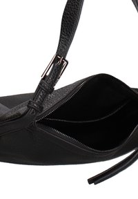 Sac en cuir noir avec un extérieur texturé, fermeture éclair et un intérieur compartimenté. Comprend une sangle ajustable et des accents en métal.