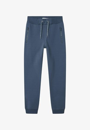 Tumbra zilas sporta bikses ar auklu jostu, ar divām kabatām ar rāvējslēdzējiem un ribotiem aprocēm. Izgatavotas no mīksta, gluda auduma.