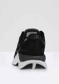 Scarpa sportiva nera con tomaia in rete, collo imbottito, dettaglio del logo e suola bianca. Presenta un design snello e moderno.