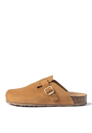 Zueco de ante marrón con correa ajustable y hebilla dorada, plantilla de corcho y suela de goma, mostrado en perfil lateral sobre fondo blanco.