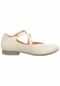 Chaussure blanche en cuir avec un petit talon, ornée de brides croisées, à bout arrondi et à la texture lisse. Doublure intérieure en daim.
