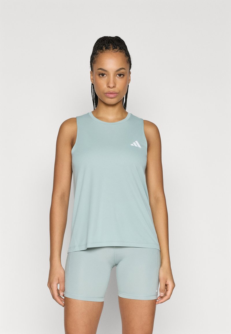 Helehall sinine varrukateta top ümmarguse kaelusega, valmistatud pehmest kangast. Kaasas sobivad kitsad lühikesed püksid ja väike valge logo detail.