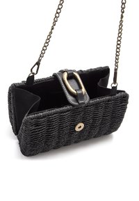 Sac à main tissé noir avec une finition texturée, présentant une boucle en métal doré, des accents en cuir et une bandoulière en chaîne. Compartiments intérieurs visibles.