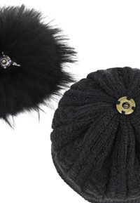 Cappello di maglia nero con un design testurizzato e un accento circolare dorato sulla parte superiore. Un pompon di pelliccia nera separato è attaccato nelle vicinanze.