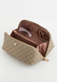 Beige stof kosmetikpose med geometrisk mønster, guldfarvet hardware og en lyserød inderside med flere lommer og en lynlåslukning.
