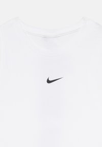 Vit ärmlös T-shirt i slätt tyg, med en liten svart Nike-logga centrerad på bröstet och rundad halsringning.
