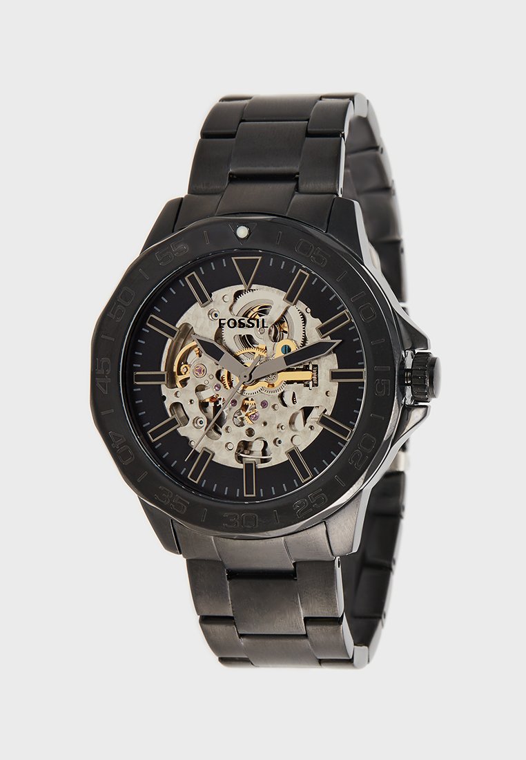 Orologio da polso Fossil nero con ingranaggi meccanici a vista, cinturino in metallo nero a maglie e indicatori e lancette delle ore luminescenti.