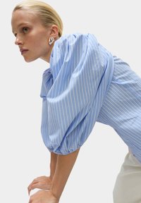 Hellbluse mit gestreiftem Muster, puffärmeln und gerafftem Bündchen. Glattes Gewebe mit subtilem Glanz und lässiger Passform.